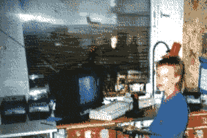 A kid in front of a desk with a Commodore 64 and a portable TV in 1989